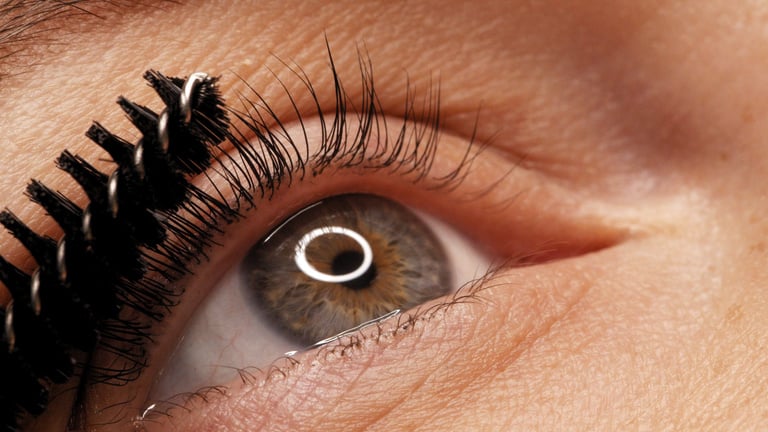 Applying Black Mascara to the Eyelashes with a Makeup Brush. App