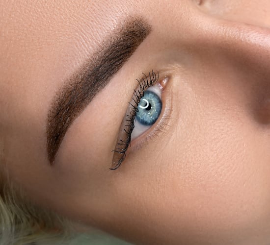 womans beautiful brow close up, natural make up and tattoo permanent